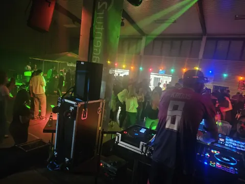 Blick vom DJ-Pult auf Gäste und Tanzfläche im Saal