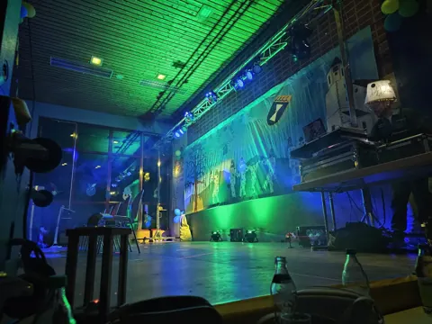 Grün und blau beleuchtete Fasnetsbühne in der Festhalle