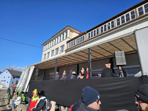 Sprecher und Mitwirkende auf einer mobilen Lkw-Bühne bei der Fasnet
