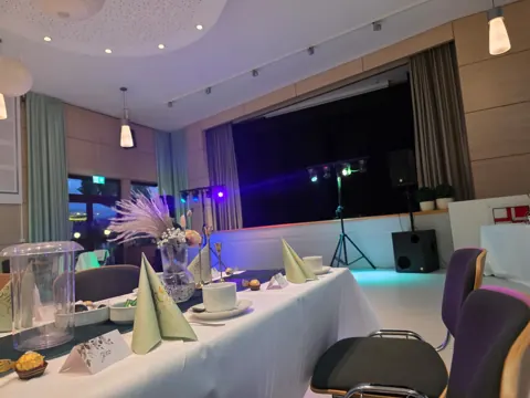 Festlich gedeckter Tisch mit Blick auf Bühne und Partylicht
